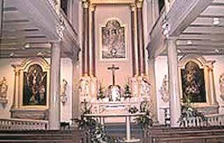 Interior view of the Chapel of the Blessed Sacrament featuring altars and religious artwork.