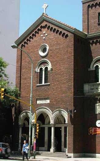 Exterior view of the parish church with brick facade and arched entrances.