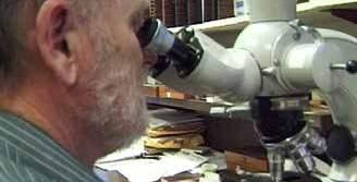 A man examining a sample under a microscope in a laboratory setting.