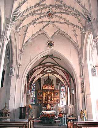 Interior view of the Church of St. Oswald featuring the altar and architectural details.