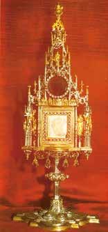 An ornate reliquary with intricate designs, set against a red background, showcasing a central compartment.