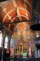 The image shows the interior of a church with ornate decorations and a painted ceiling.