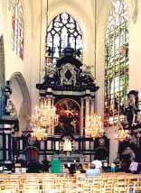 Interior view of a church featuring stained glass windows and an altar.