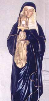 A statue of a woman in religious attire holding a monstrance.