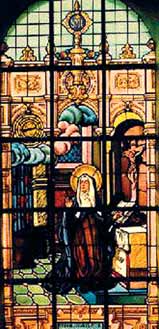 A stained-glass window showing a religious scene with a kneeling figure and ornate architectural details.