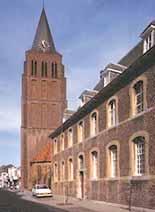 A tall brick church tower next to a building, showcasing a historical architectural style.