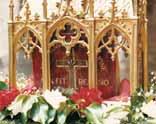 A golden reliquary containing the relic of the miraculous blood, adorned with flowers.