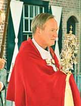 A priest in a red robe carries the relic of the blood-stained corporal during a procession commemorating the Boxtel miracle.