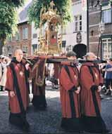 Men in ceremonial robes carrying a religious relic during a public procession.