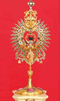 A golden monstrance adorned with jewels, used to display the Eucharistic relic.