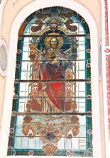 A stained glass window depicting a saint in vibrant colors and intricate designs.