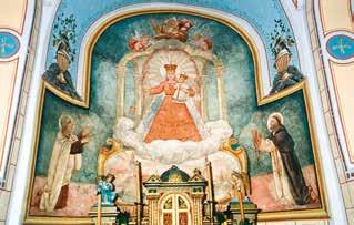 A mural depicting the Virgin Mary with angels and saints in a church setting.