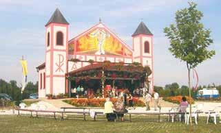 A colorful shrine with a large cross and people gathered around it.