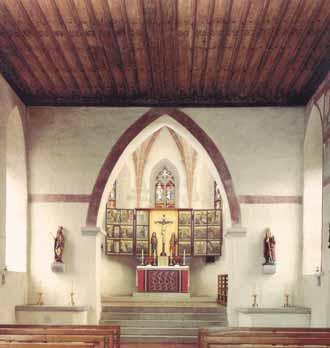 The image shows the interior of a church shrine with an altar and wooden ceiling.