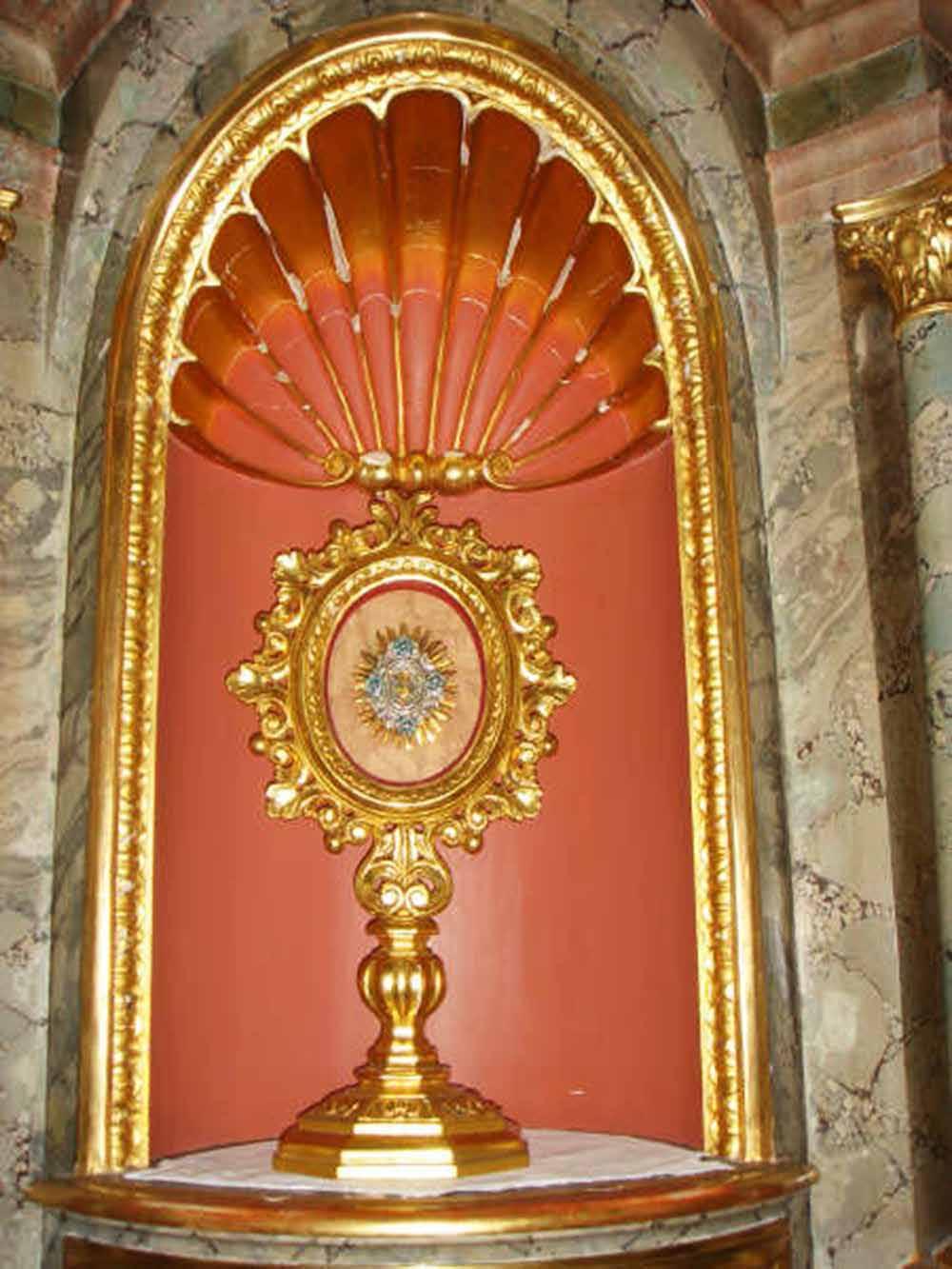Golden monstrance in Ettiswil church niche, commemorating the 1447 Eucharistic miracle involving Ann Vögtli's attempted theft.