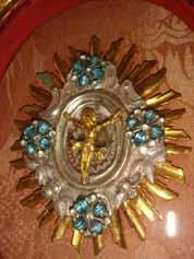 Golden sunburst with Christ figure, symbolizing Ettiswil's 1447 Eucharistic miracle, adorned with blue gems.