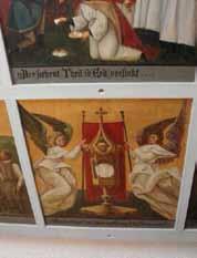 Two angels holding a monstrance with a cross and a sacred host.