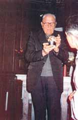 A man holding a small container with a religious object, possibly a relic or host.