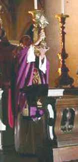 A priest holds a monstrance with the miraculous Host during a religious ceremony.