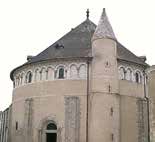 A round, stone church building with a conical tower and arched windows.