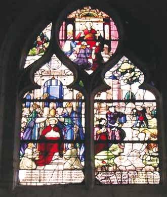 A stained glass window depicting religious figures and scenes in vibrant colors.