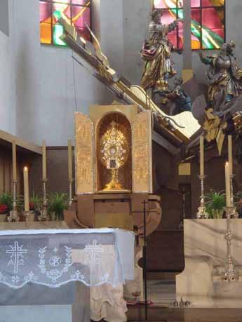 A golden monstrance on an altar, symbolizing the Augsburg miracle where a woman preserved the Eucharist at home.