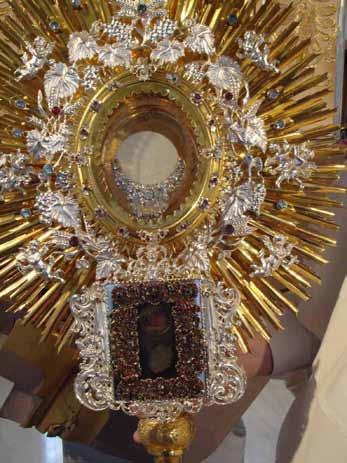 A golden monstrance adorned with intricate designs and a central relic.