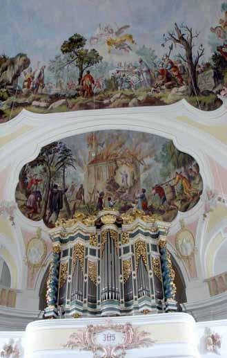 The image shows a decorated organ with a mural above depicting biblical scenes.