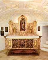 The ornate altar in Erding's chapel, built to honor the 1417 Eucharistic miracle, features intricate carvings and a central statue.