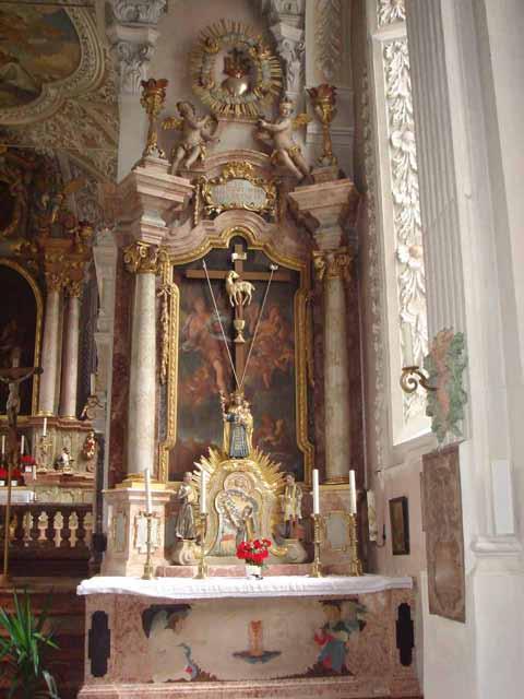 An ornate altar in Erding, Germany, featuring a crucifix and angelic figures, symbolizing the 1417 Eucharistic miracle.
