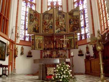 The altar of Kranenburg church, adorned with a detailed altarpiece, commemorates the 1280 Eucharistic miracle of the 'Miraculous Crucifix.'