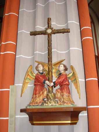 Two angels holding a cross, with ornate details and vibrant colors.