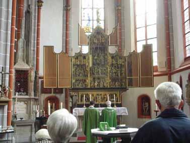 Congregants witness Mass at Kranenburg's altar, linked to the 1280 Eucharistic miracle of the 'Miraculous Crucifix.'