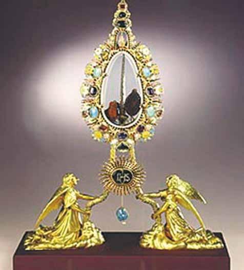 A golden reliquary with angels holding a glass case containing sacred relics.