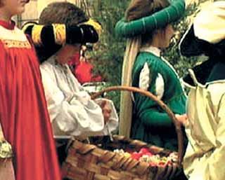 Children dressed in historical costumes, holding a basket, likely during a procession or festival.