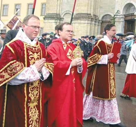Clerics in ceremonial robes carrying a relic during a procession.