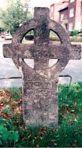 A stone cross monument with a circular design, likely commemorating the Eucharistic Miracle.