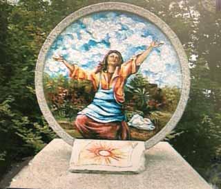 A colorful mosaic depicting a woman with outstretched arms in a natural setting.