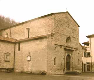 A sepia-toned image of an old stone church with a simple facade and arched entrance.