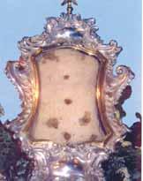 An ornate reliquary displaying a blood-stained cloth, significant to the Eucharistic miracle.