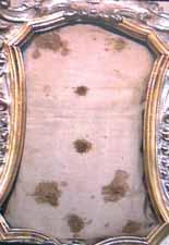 An ornate frame containing a cloth with several dark stains, believed to be blood.