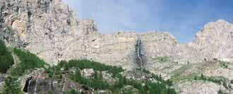 Panoramic view of Canosio's rocky cliffs and waterfall, illustrating the natural setting of the 1630 Eucharistic miracle.