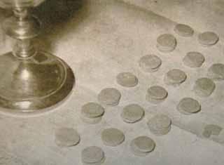A close-up of consecrated Hosts arranged on a surface next to a chalice.
