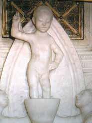 A marble statue of a child holding a gesture, possibly representing a religious figure.