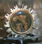 A golden reliquary containing fragments of consecrated Hosts preserved after a church fire.