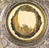 The image shows a circular relic encased in an ornate frame, likely related to the Eucharistic Miracle.