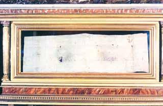 A relic cloth stained with blood, displayed in a decorative frame.