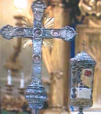 A silver cross and a reliquary containing the miraculous Host from the Eucharistic miracle.