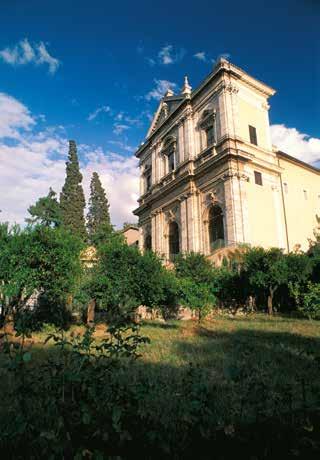 The Church of St. Gregory in Rome, where a Eucharistic miracle involving Pope Gregory occurred, stands amidst lush greenery.
