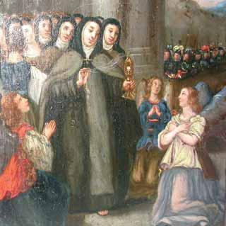 Saint Clare holds the Eucharist while nuns and a woman pray amidst soldiers.
